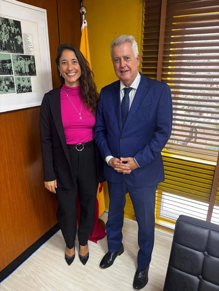Natália Rinco ao lado de uma liderança histórica do PSB, com a bandeira do partido ao fundo.