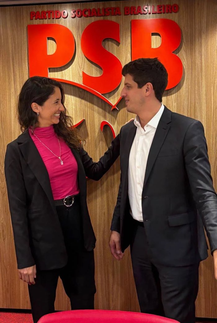 Natália Rinco em conversa com um dirigente do partido, diante do letreiro do PSB na sede nacional.